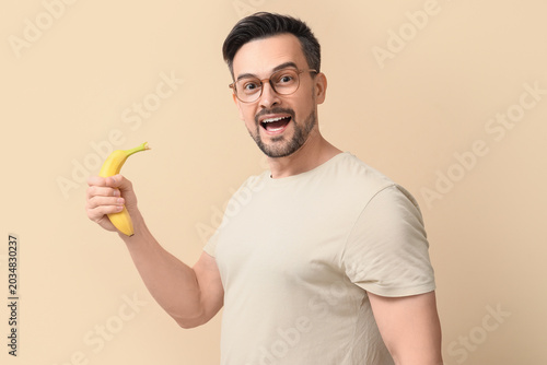 Happy young man with banana...