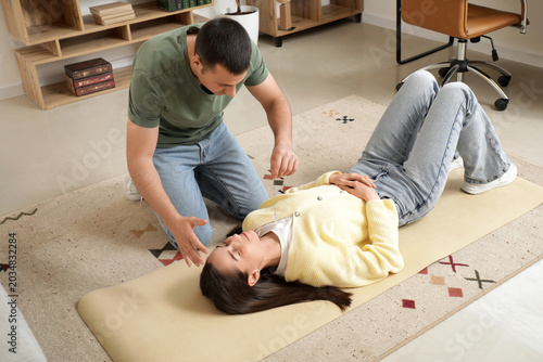 Foto Male psychologist with pendulum hypnotizing woman in office