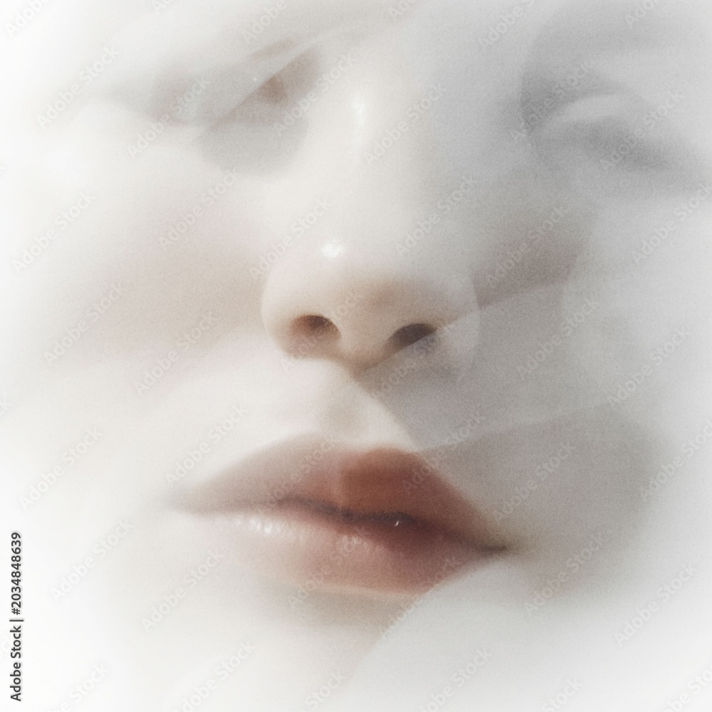 Fototapeta premium an artistic double exposure portrait of a person's face blended softly with white misty textures that create an ethereal and dreamlike effect