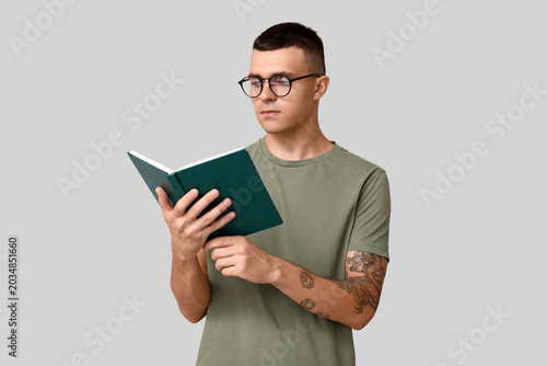 Handsome young man reading ...