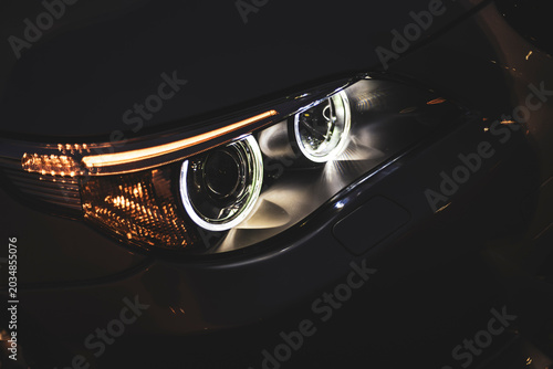 Foto Close-up of modern car headlight shining in the dark