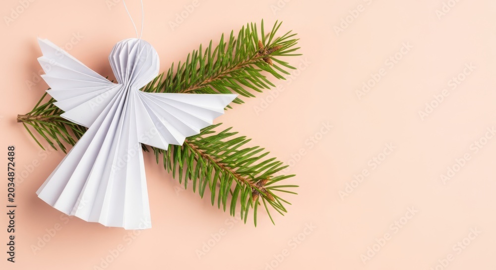 Obraz premium Paper angel ornament with fir tree branches on a soft pink background