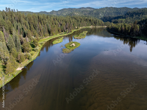 Serene lake reflects the sky and forested hills above