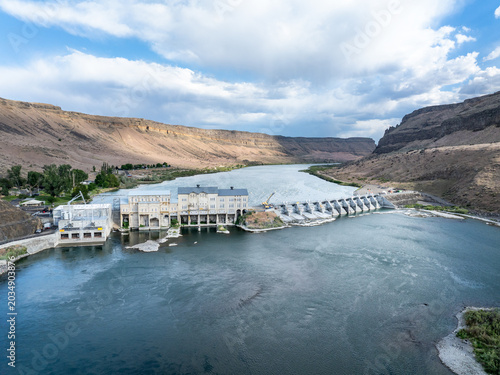 Serene lake reflects the dam's structure and the surrounding landscape