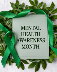 A light green card with 'MENTAL HEALTH AWARENESS MONTH' text, surrounded by vibrant green leaves and a symbolic green awareness ribbon, set against a textured white background.