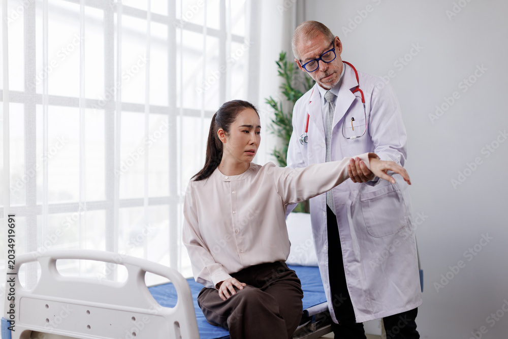 Obraz premium Doctor examining a female patient's arm and shoulder, identifying a painful injury, focusing on joint mobility and physical rehabilitation for effective medical treatment