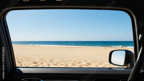 Sunny beach and calm ocean as seen through a car window