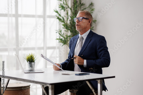 Photos Senior businessman experiencing stress and burnout, unbuttoning shirt to allevia