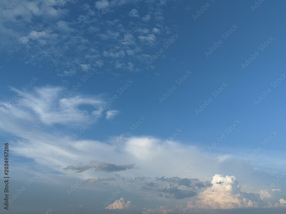 Naklejka premium Panoramic view of vibrant blue sky filled with fluffy white cumulus clouds and wispy cirrus patterns. Nature background perfect for backgrounds, wallpaper, presentation backdrop, graphic design.