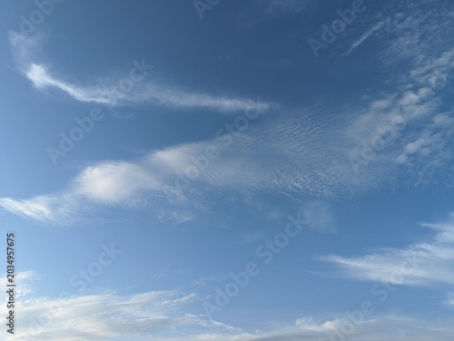 Bild auf Leinwand Bright blue sky background with scattered wispy white cirrus and cirrocumulus clouds