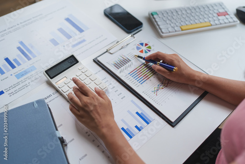 Fotografía Person analyzing financial data using calculator and charts