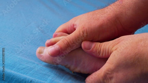 Taking care of your own body. Foot massage.Сlose-up shot of a man’s hands massaging his tired foot after a long work day. Filmed in soft, natural daylight. 