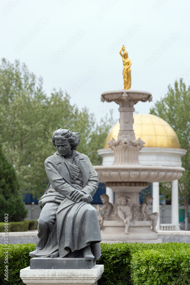 Obraz premium A Beethoven statue and European-style garden fountain in the Italian Style Town district of Tianjin, cityscape photography
