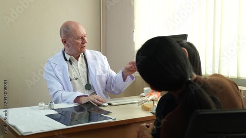 The doctor is providing counseling to the parents who brought their daughter in for a medical checkup.