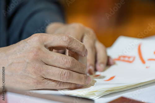Photography elderly man holding seal stamping on calligraphy paper