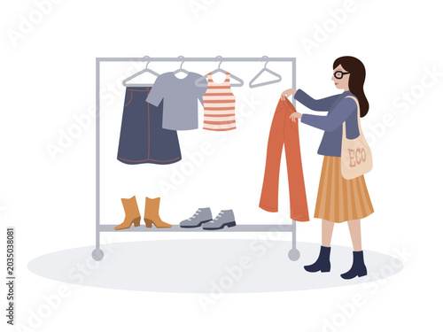 Sustainable fashion, woman choosing clothes from the rack in second hand shop or thrift store.