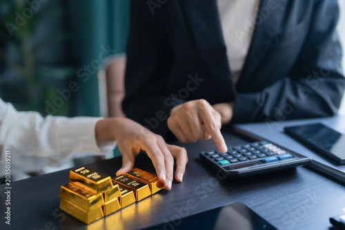 Obraz na plátne Asian businesswoman holding gold bar for investment trading and wealth managemen