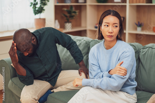 Photography Multiracial adult couple sitting on couch in their apartment