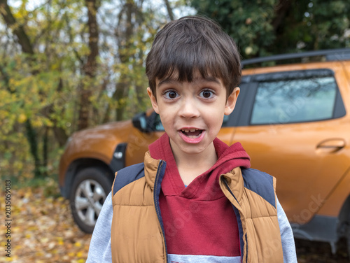Surprised Little Boy in Autumn Park Looking Excited at Camera