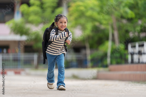 Canvas Print Cheerful student with backpack running happily on her way home from school
