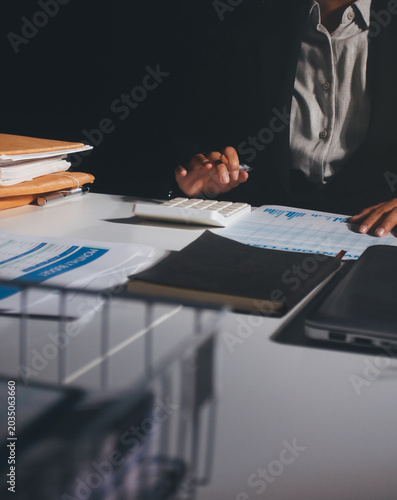 Professional photo of a person's hands reviewing a contract or legal document on a desk, for concepts of business, finance, and legal affairs