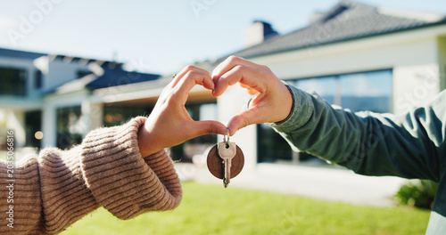 Photos Couple, key and moving in backyard with heart hands, bonding and real estate purchase of new home