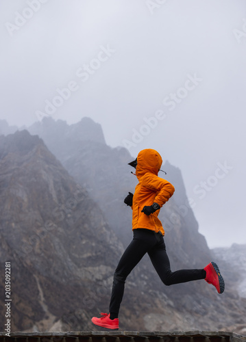 Trail runner running in winter snow capped mountains