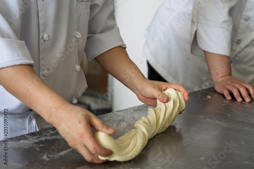Foto Pastry chef kneading pasta dough on workbench