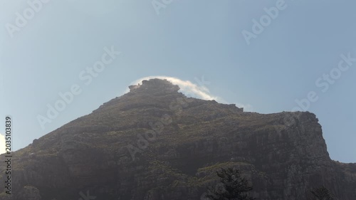 Clouds moving at high speed behind mountain peak. Cape Town area, South Africa.