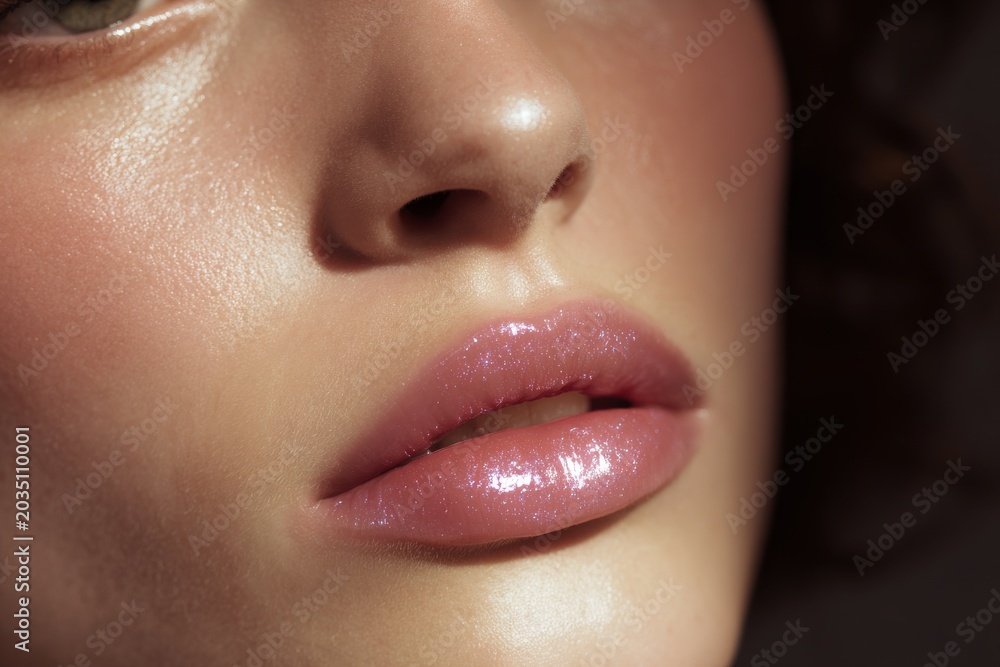 Fototapeta premium Closeup glossy iridescent model lips with luminous wet shine for beauty banner design and cosmetic advertising background for skincare and lip gloss campaigns