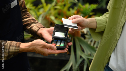 Foto Cropped Shot of Customer Using Credit Card Payment via EDC Machine at SME Plant