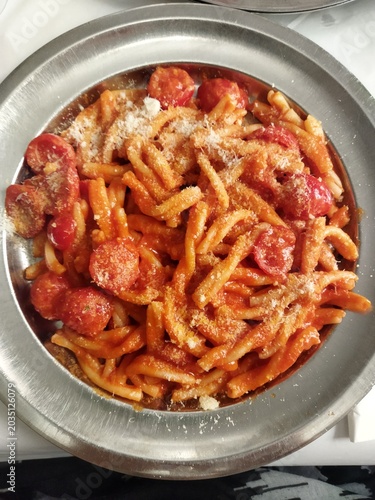 Φωτογραφία Plato de pasta tradicional italiana Strozzapreti al pachino y queso rallado en una fuente de metal