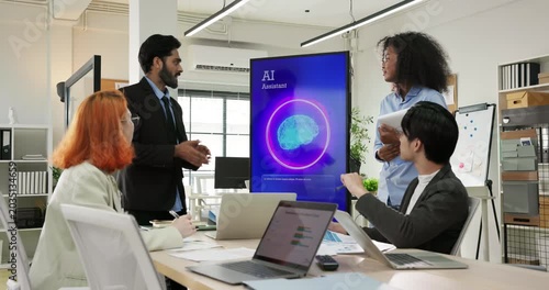 Group of diverse young office workers having a business meeting and collaborating with an AI assistant on screen. Future workplace, generative AI integration, and team brainstorming concept.