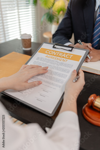 Professional legal consultation meeting between lawyer and client in office, discussing case documents, legal advice, contract review, negotiation, and justice services in a corporate setting.