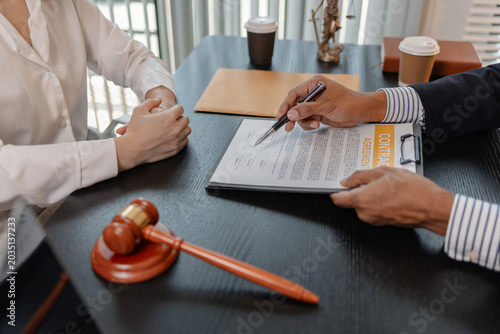 Professional legal consultation meeting between lawyer and client in office, discussing case documents, legal advice, contract review, negotiation, and justice services in a corporate setting.