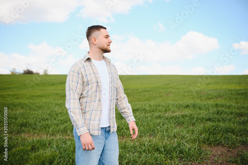 Photos Farmer observing growth in young green wheat field