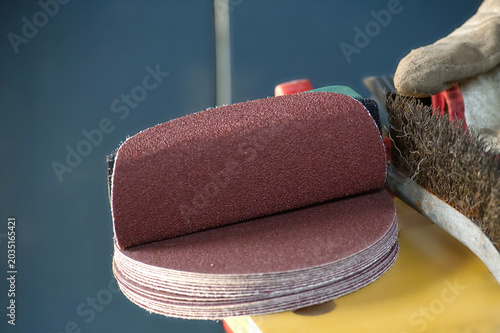 фотографія Stack of abrasive sanding discs ready for use with a wire brush and glove