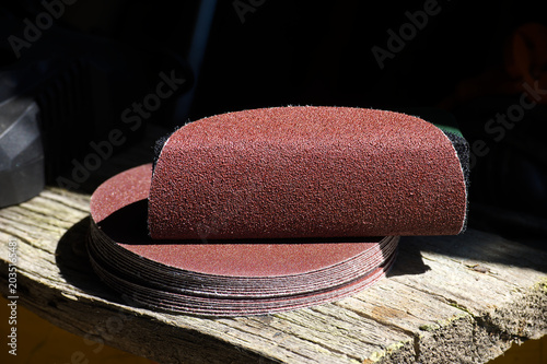 Stack of circular sanding discs for power tools on weathered wood surface