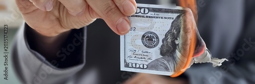 Foto Burning a hundred-dollar bill to express discontent with financial systems