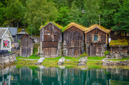 Old traditional houses on the coast of Geirangerfjord in town Geiranger, one of the most beautiful fjords in Norway