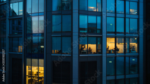 Bild auf Leinwand Office building at night with lit interior business district building architectu