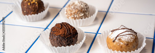 Foto Four mini muffins—two chocolate and two vanilla—topped with decorative sprinkles or glaze, perfect for snacking, dessert, or sharing sweet treats