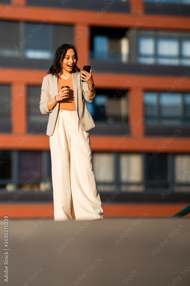 Obraz premium Excited woman receiving good news on smartphone
