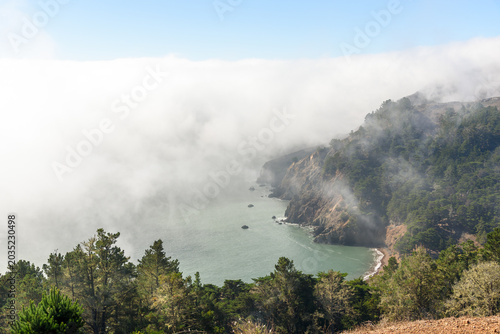Bay partly covered with fog drifting form the ocean along the coast of California in autumn