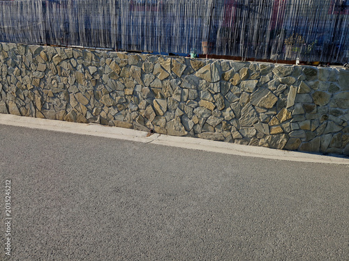 Foto retaining wall with facing stone cladding made of irregular chipped often referred cyclopean masonry or wild stone