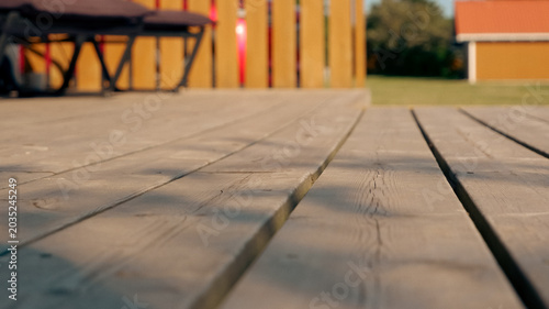 Close up of a wooden terrace deck with sunlight and shadows in a backyard setting