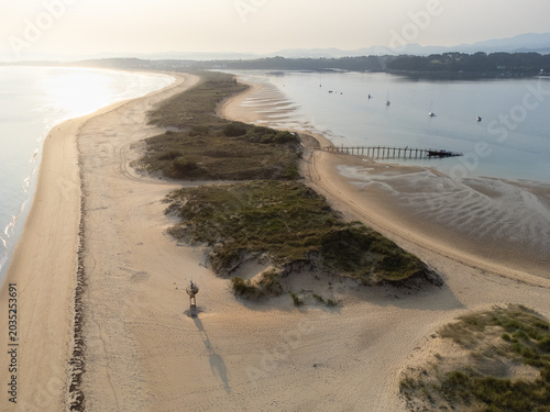 Early morning aerial view of El Puntal spit stretching into the distance with its empty sandy beach. Somo, Cantabria, Spain.