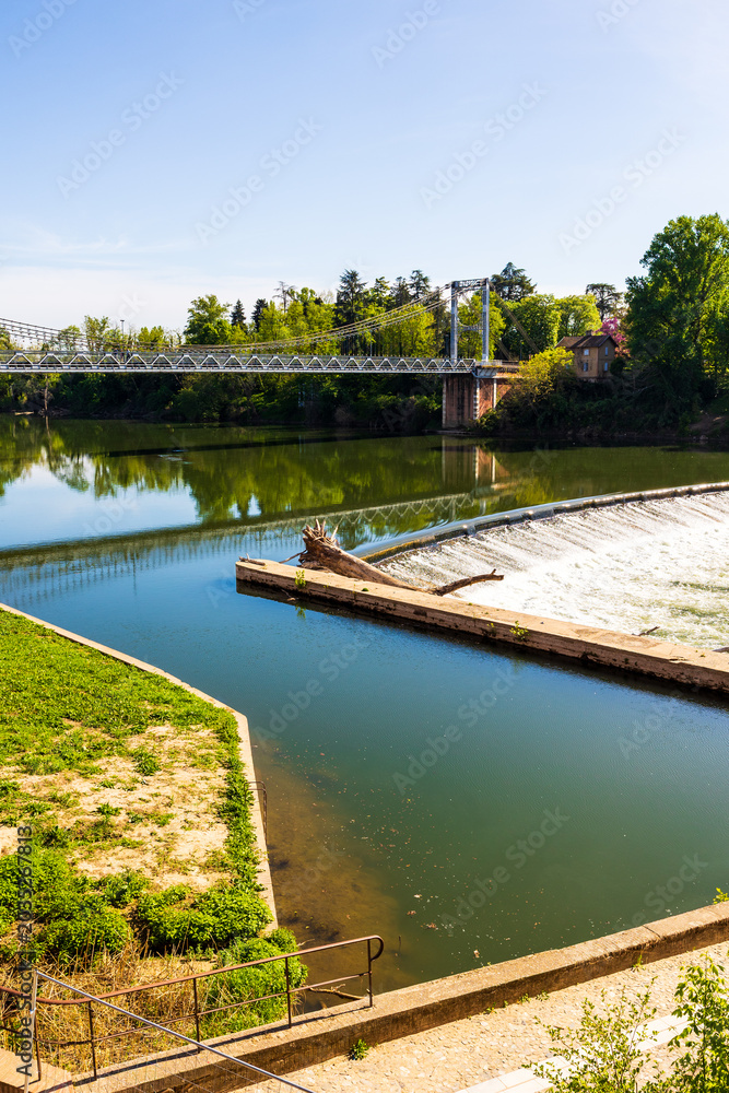 Fototapeta premium Suspension bridge crossing the Tarn river linking the historic center of Villemur-sur-Tarn to the rest of the municipality
