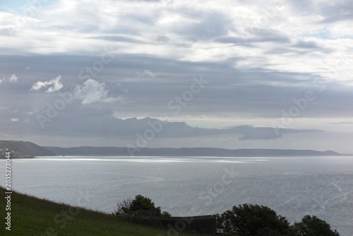 Dark moody clouds over Whitsand bay from Looe Cornwall