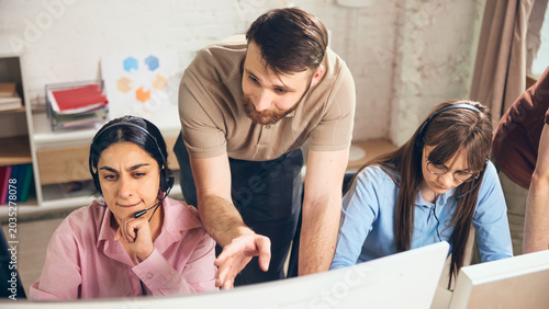 фотографія Support supervisor helping operators solve client request in office